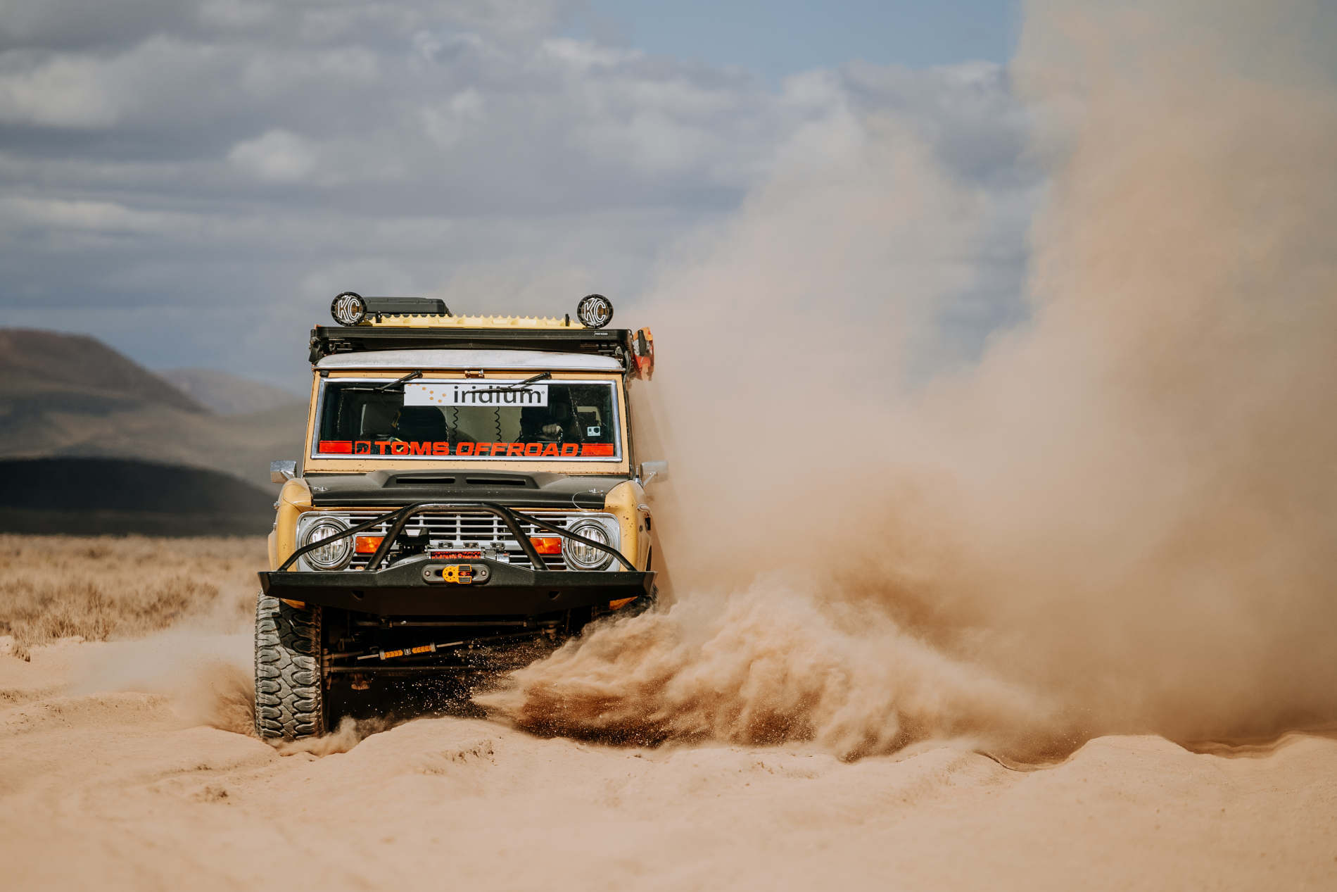 Action shot of 2021 Rebelle Rally Team Roaming Wolves driving through desert and kicking up big dust trail